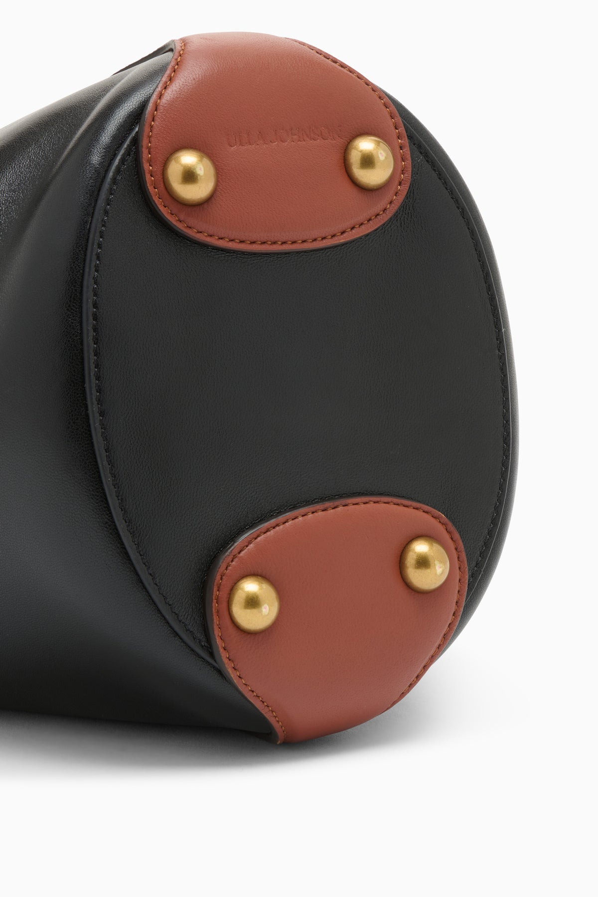 Black Leather Bucket Bag Base Detail, Gold Hardware and Tan Leather Tabs | Ulla Johnson